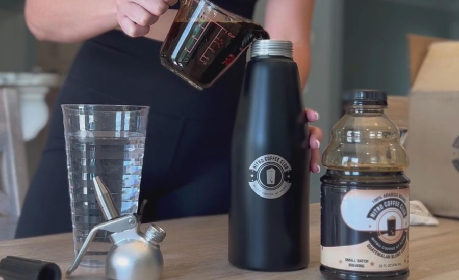 Pouring cold brew coffee into a keg or container.