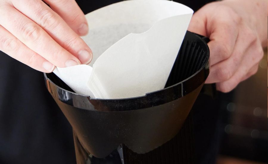 Hand holding a coffee filter.