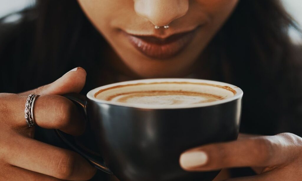 Steam rising from a cup of freshly brewed white coffee.